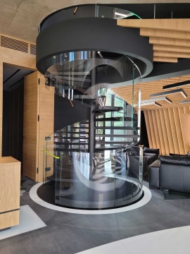 Schody spiralne nowoczesne wewnętrzne ze stali nierdzewnej + balustrada z giętego szkła.