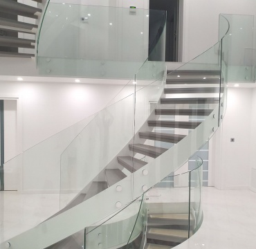 Nowoczesne schody na stalowej konstrukcji ze szklaną balustradą