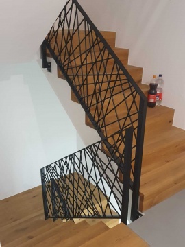Schody drewniane z nowoczesną barierką schodową w czarnym kolorze