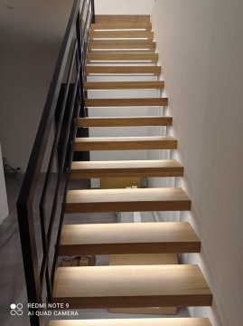 Nowoczesne schody z podświetleniem LED i czarną balustradą w stylu loftowym - front