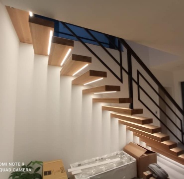 Nowoczesne schody z podświetleniem LED i czarną balustradą w stylu loft - front