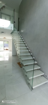 Schody kamienne z białego marmuru ze szklaną balustradą w nowoczesnym domu - fot.1