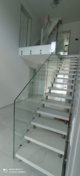 Schody kamienne z białego marmuru ze szklaną balustradą w nowoczesnym domu - fot.2
