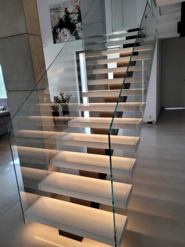 Nowoczesne schody kamienne jednobelkowe na metalowej konstrukcji z podświetleniem LED + szklana balustrada