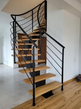 Nowoczesne schody w stylu industrialnym na belce centralnej z drewnianymi stopniami i czarną balustradą.